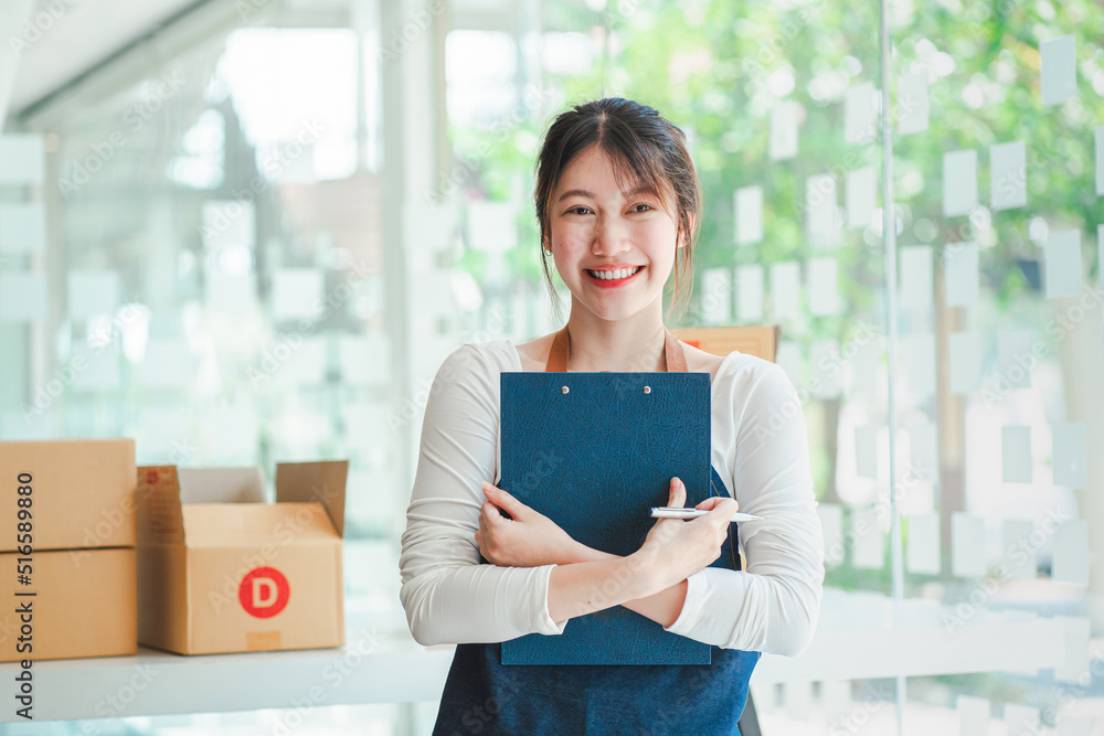 Portrait of a Small Business Startup, SME Owner, Female Entrepreneur work on parcel boxes Receipts and check orders online to prepare boxes. Selling to customers. Online SME business idea. Portrait of a Small Business Startup, SME Owner, Female Entrepreneur work on parcel boxes Receipts and check orders online to prepare boxes. Selling to customers. Online SME business idea.
