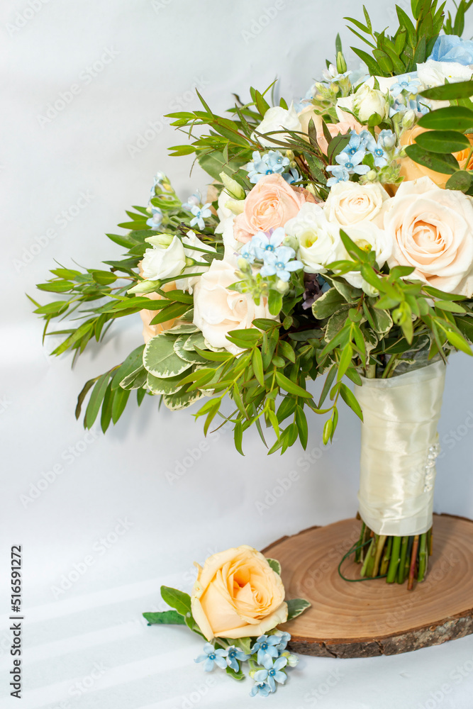 Brides bouquet and matching suit boutonniere with roses and small blue flowers, cropped view with copy space. Brides bouquet and matching suit boutonniere with roses and small blue flowers, cropped view with copy space.