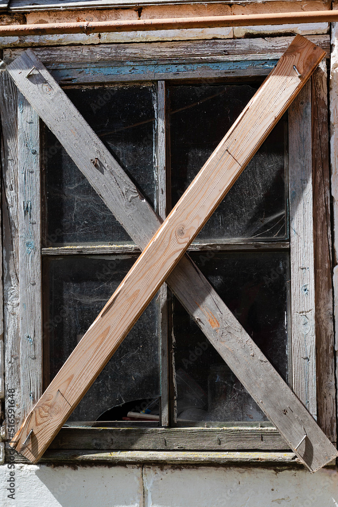 An old window in an old abandoned house. The concept of poverty and material inequality. An old window in an old abandoned house. The concept of poverty and material inequality.