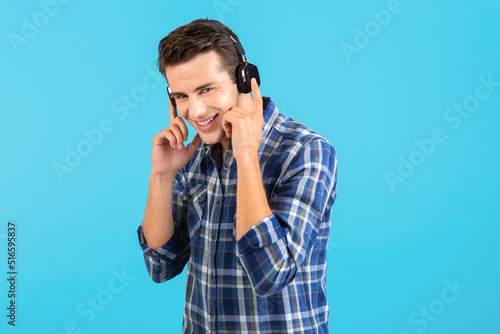 stylish young man listening to music on wireless headphones
