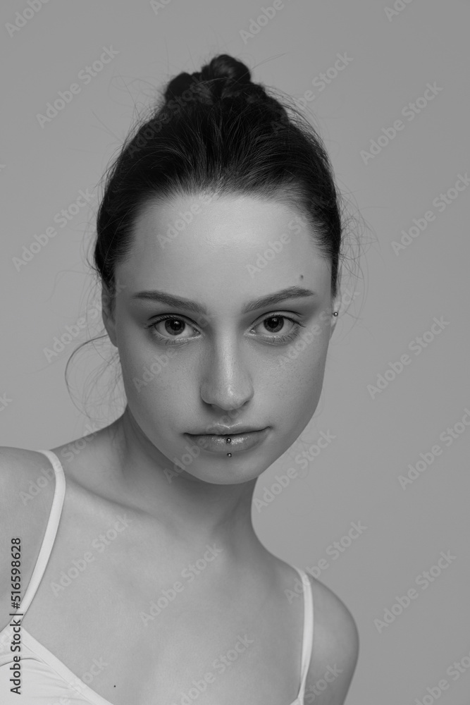 Portrait of young beautiful girl with natural makeup posing, looking at camera. Black and white photography Portrait of young beautiful girl with natural makeup posing, looking at camera. Black and white photography