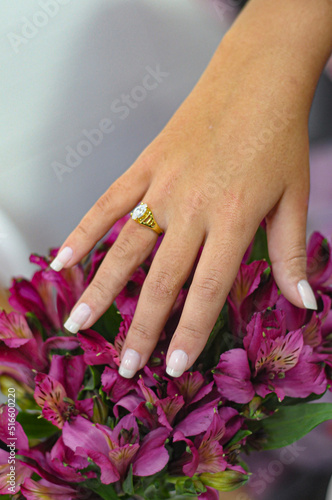 Female hand over a bouquet of purple flowers