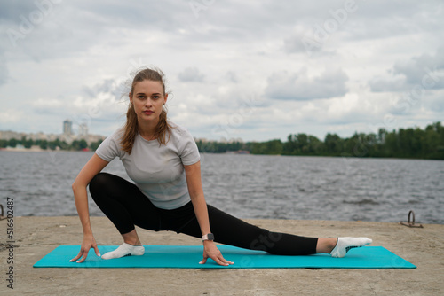 sports girl doing stretching near the river
