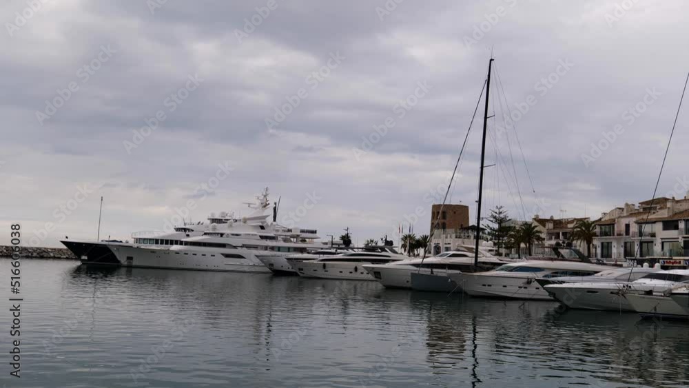 sliding shot of the marina with all the large yachts moored side by side in Puerto Banus in Marbella, Spain sliding shot of the marina with all the large yachts moored side by side in Puerto Banus in Marbella, Spain
