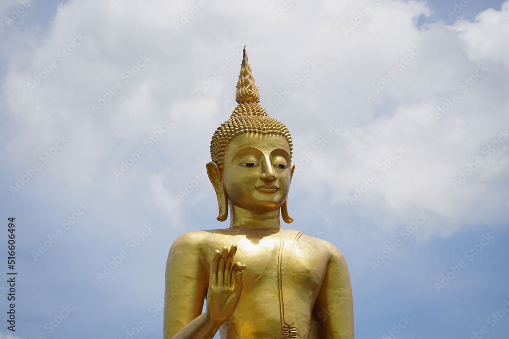 Goldene Buddha-Statue vor grauen Wolken