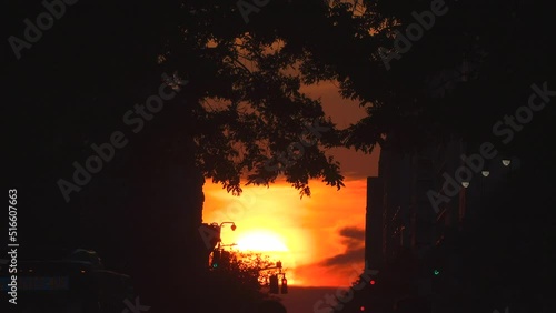 NEW YORK, NEW YORK – JULY 11: The sun sets into middle of the 14th Street among buildings during the Manhattanhenge on July 11, 2022 in New York City. 