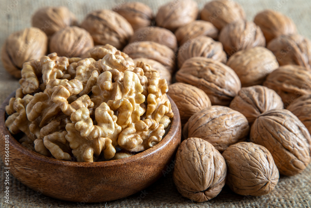 Peeled walnuts and whole walnuts on burlap sack Peeled walnuts and whole walnuts on burlap sack