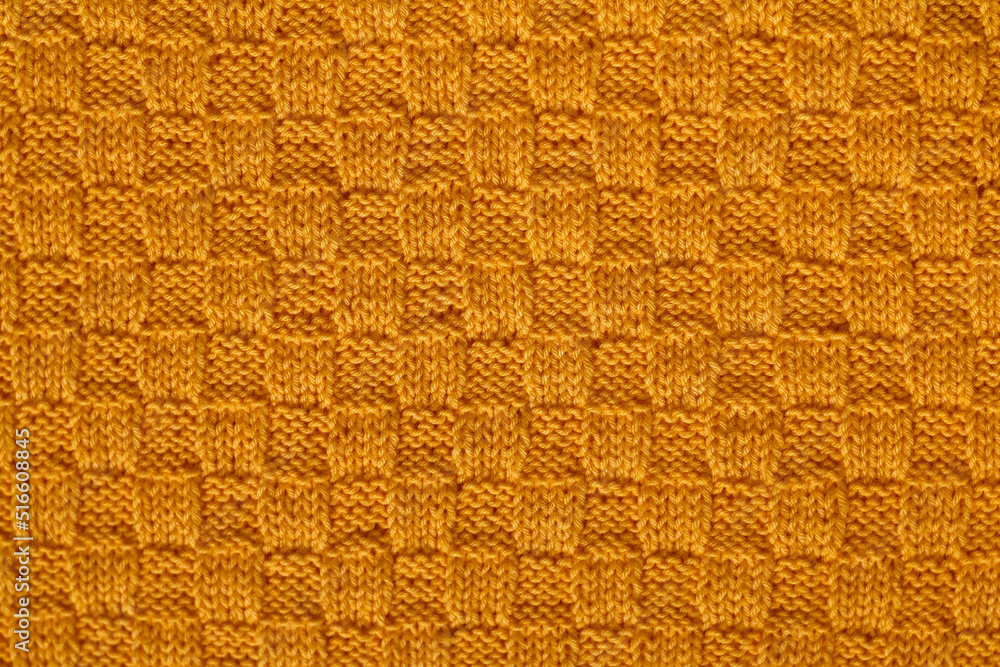 Fototapeta premium Yellow soft knited texture. Knitted chess pattern. Knited background.