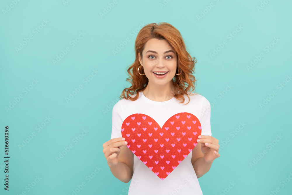positive redhead woman hold red heart on blue background positive redhead woman hold red heart on blue background