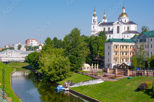 Vitebsk, Belarus - JUNE 26, 2022 : Vitebsk City Skyline with Resurrection Church Across The Vitba River. Holy Assumption Cathedral of the Assumption on the hill and the Holy Spirit convent.