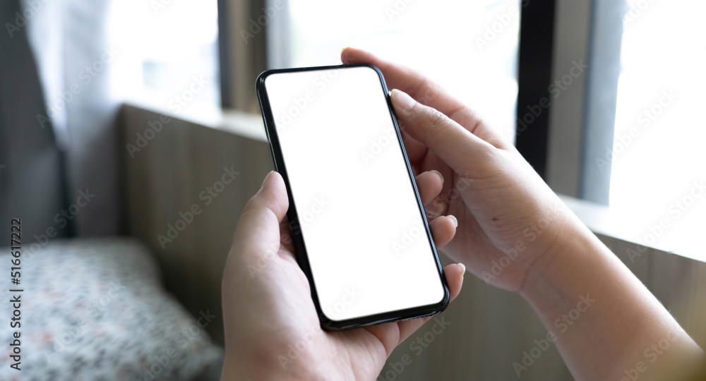 Young Asian woman using smartphone (white screen) at coffee shop. technology and bussiness concept background. Young Asian woman using smartphone (white screen) at coffee shop. technology and bussiness concept background.