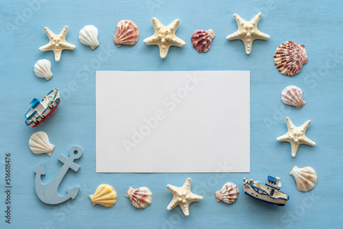 Blank notebook paper, seashells, starfishes on blue wooden background.