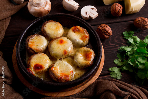 Traditional Georgian dish, appetizer, stuffed mushrooms, Sulguni cheese, baked in a Ketzi clay pan, on a wooden table, close-up, no people,