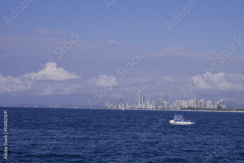Boat on the sea in front of the skyline of Gold Coast city, Australia