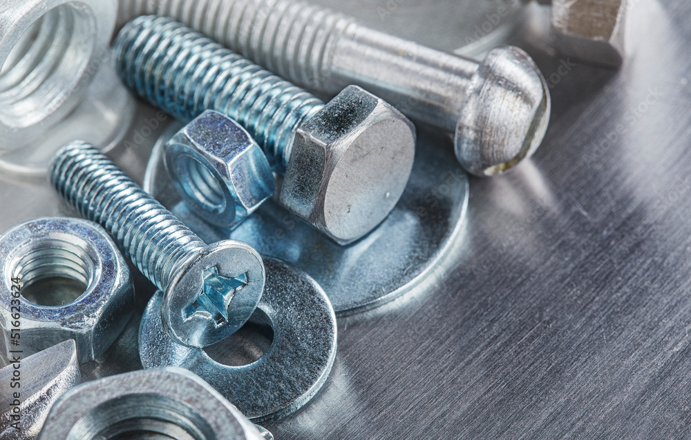 set of different nuts, bolts, screws, washers and drill bits,thread tap and mill cutters on steel plate background. Locksmithing deal. set of different nuts, bolts, screws, washers and drill bits,thread tap and mill cutters on steel plate background. Locksmithing deal.