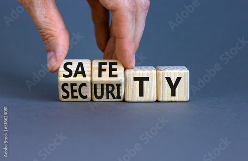 Safety and security symbol. Concept words Safety and security on wooden cubes. Businessman hand. Beautiful grey table grey background. Business safety and security concept. Copy space.