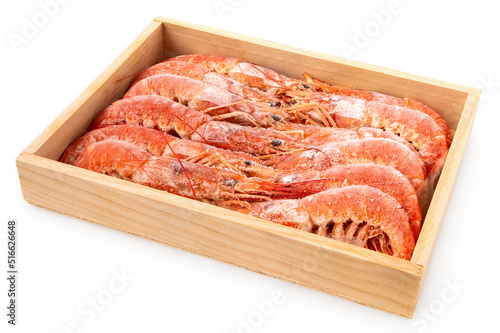 Frozen cooked red tiger shrimps in a wood box.