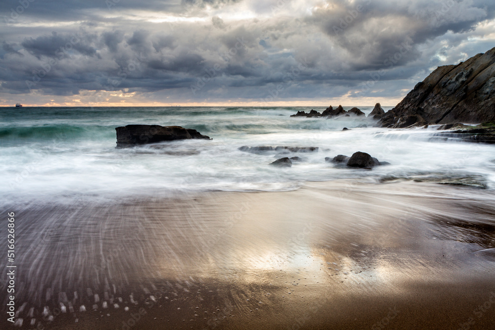 Obraz premium Sunset at Azkorri beach in the coast of Biscay, Basque Country, north of Spain. 