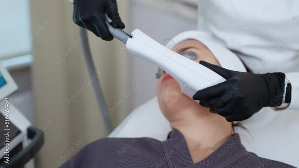 cosmetologist is using broadband light apparatus for rejuvenating female face skin cosmetologist is using broadband light apparatus for rejuvenating female face skin