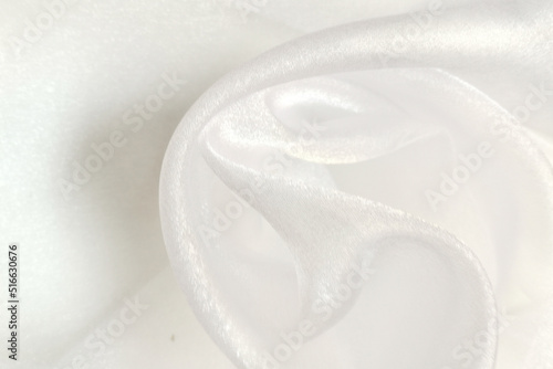 White organza fabric. Crumpled or wavy fabric texture background. Abstract linen cloth soft waves. Natural yarn. Smooth elegant luxury cloth texture. Concept for banner or advertisement.
