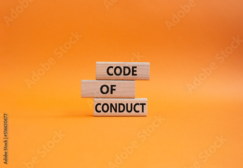 Code of conduct symbol. Wooden blocks with words Code of conduct. Beautiful orange background. Business and Code of conduct concept. Copy space. photo