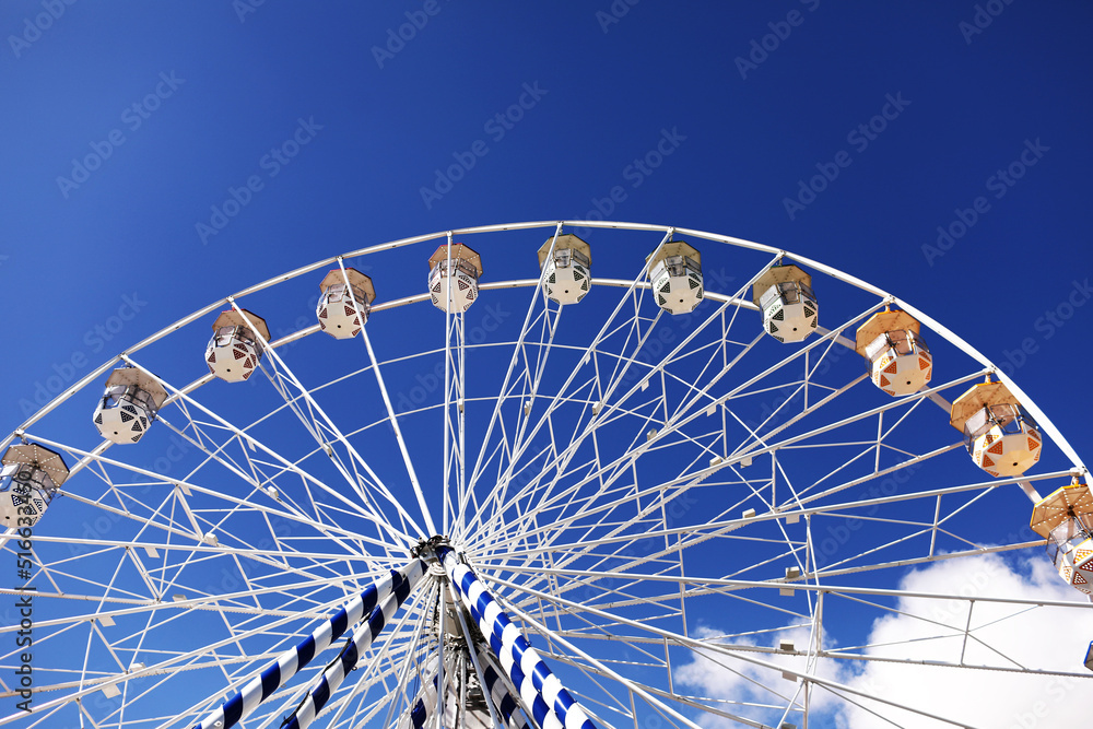 ferris wheel of the amusement park in the blue sky background. Retro colorful ferris wheel of the amusement park in the blue sky background.