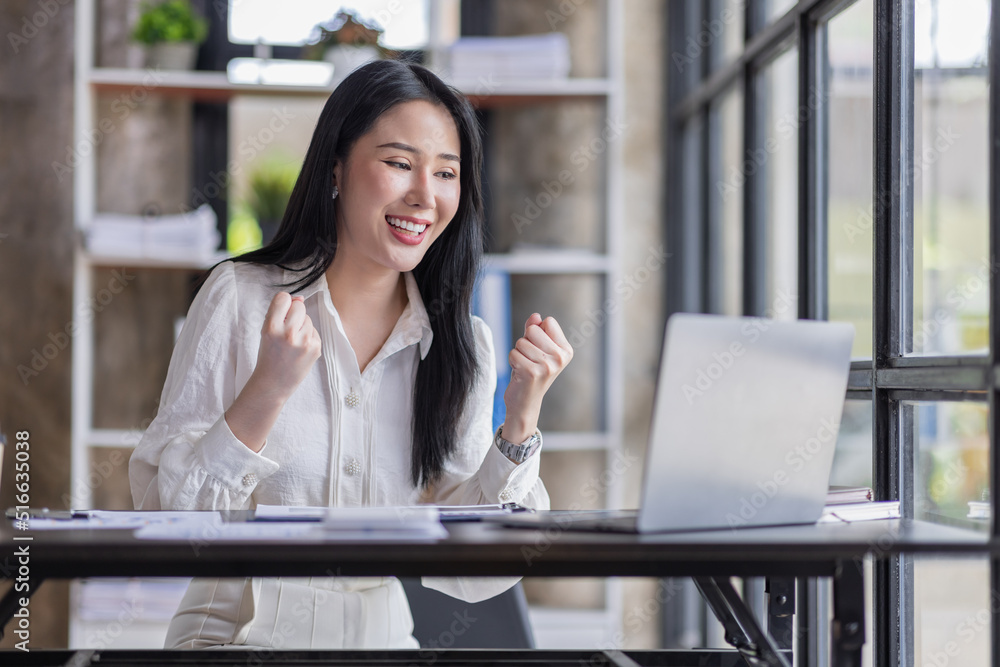 Happy excited Asian businesswoman in the office working with a laptop computer, Yes great job. Happy excited Asian businesswoman in the office working with a laptop computer, Yes great job.