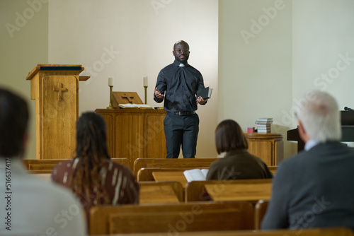 Canvastavla Confident priest of evangelical church with Holy Bible in hand saying sermon whi