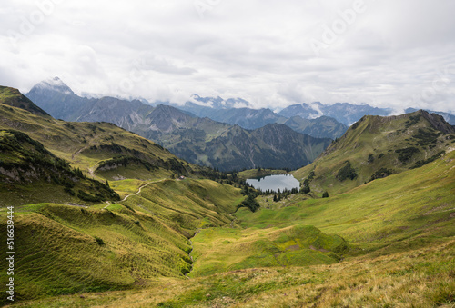 Panorama view over a green valley with a romantic lake