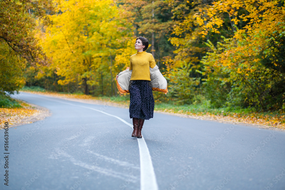 Full-length photo of young woman on road in autumn forest, walking in fresh air, enjoying freedom and solitude. Happy people Full-length photo of young woman on road in autumn forest, walking in fresh air, enjoying freedom and solitude. Happy people