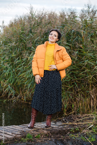 Bild auf Leinwand Beautiful young brunette woman posing in a yellow jacket, long skirt and boots