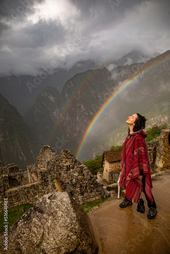 Leinwand Poster Woman and two rainbows in Inca citadel called Machupichu built of stones in the