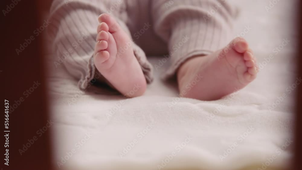 Close up shot of infant's legs. Newborn baby is lying on the bed and twitching his legs. Small feet. Funny moments. Slow motion Close up shot of infant's legs. Newborn baby is lying on the bed and twitching his legs. Small feet. Funny moments. Slow motion