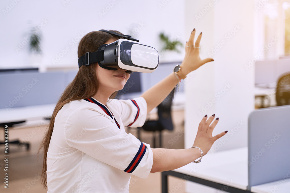 Female professional using vr virtual reality headset at desk in office