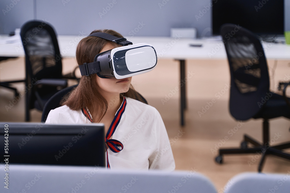 Female professional using vr virtual reality headset at desk in office