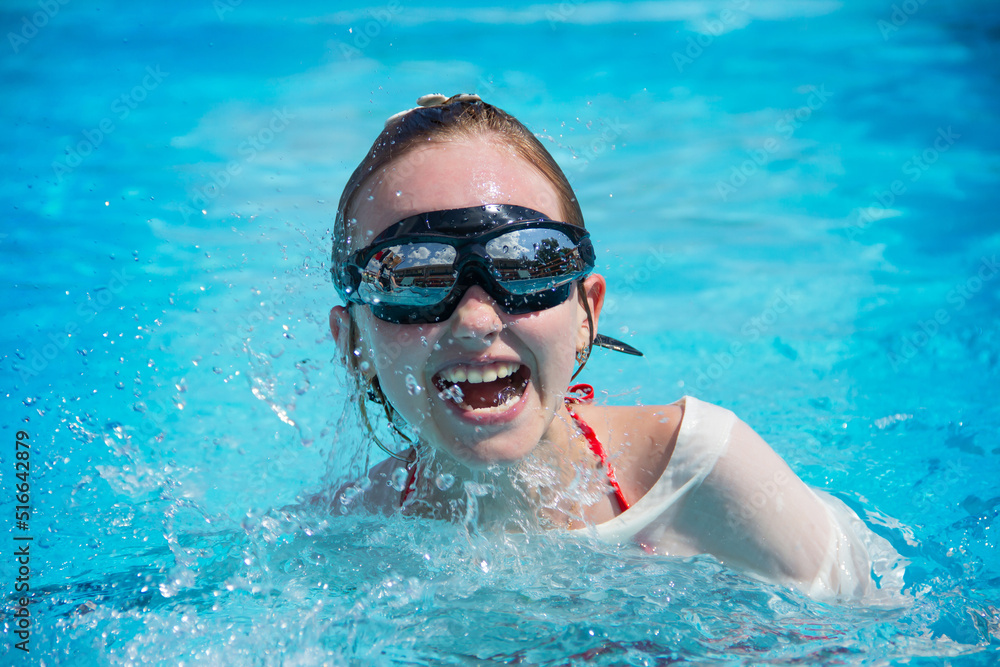 A girl with glasses swims in the pool.