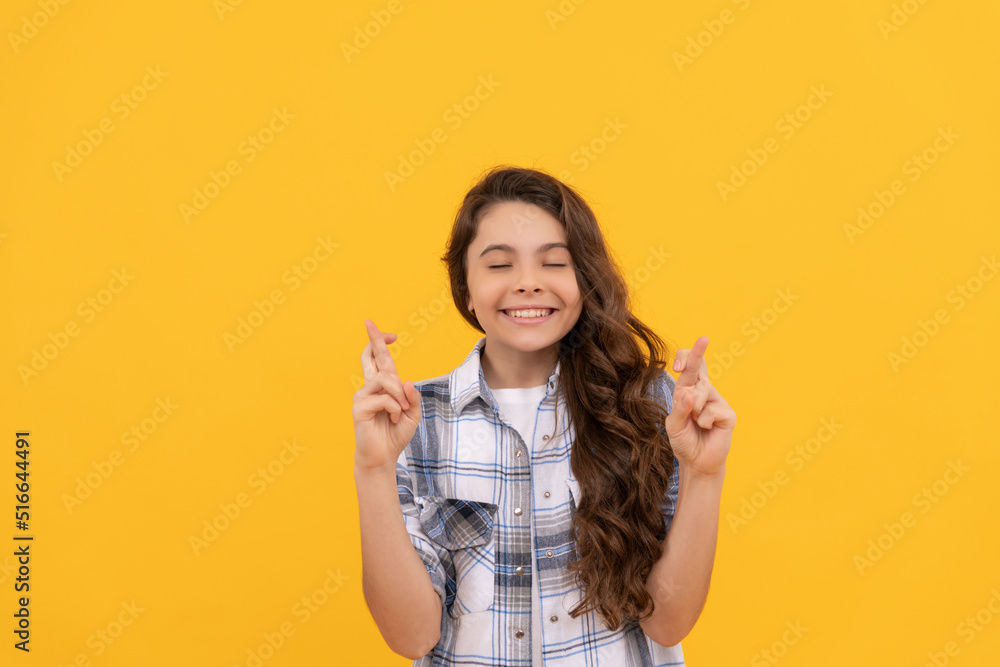 hoping teen child in checkered shirt with long curly hair on yellow background hoping teen child in checkered shirt with long curly hair on yellow background