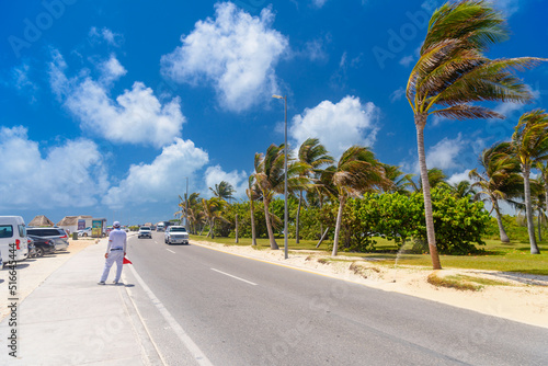 SUV driving on the road with palms on a sunny day near Cancun, Mexico