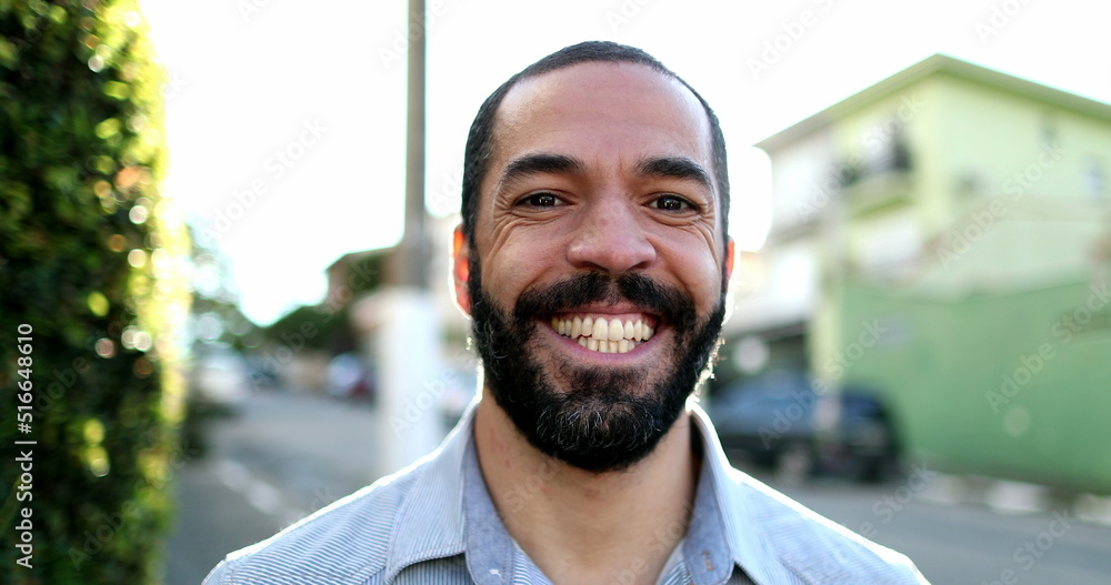 Casual Happy hispanic man in 40s smiling at camera outside in urban street Casual Happy hispanic man in 40s smiling at camera outside in urban street