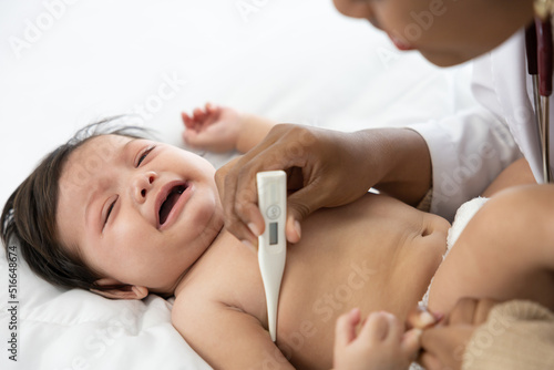 doctor measuring baby s temperature and baby crying on bedroom