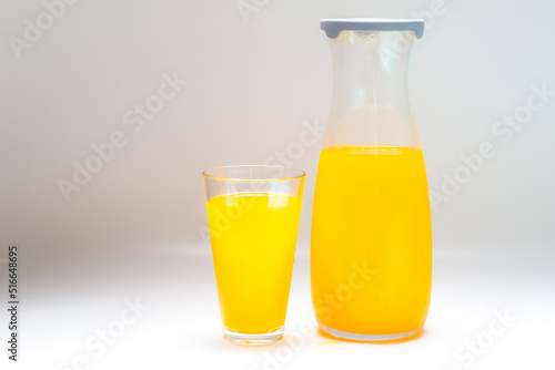 orange juice in glass cup and jug, different angles on white background