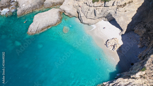 Aerial drone photo of famous pebble paradise beach of Seychelles, popular for turquoise azure waters and natural volcanic cave formations, Ikaria island, Northeast Aegean, Greece