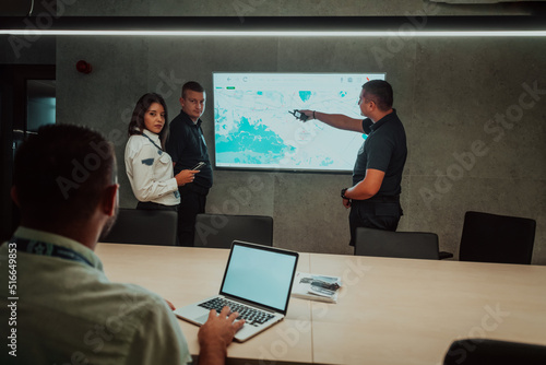 Group of Security data center operators working in a CCTV monitoring room looking on multiple monitors Officers Monitoring Multiple Screens for Suspicious Activities Team working on the System Contr