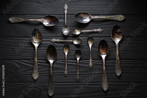 Directly above a shot of old spoons on a black table
