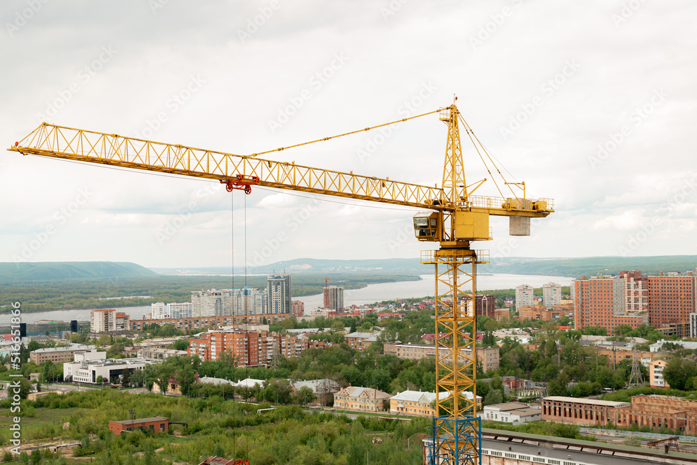 tower crane top view. building background river, sunset, mountains. concept construction, new buildings, architecture and industry. construction big city against backdrop city mountains
