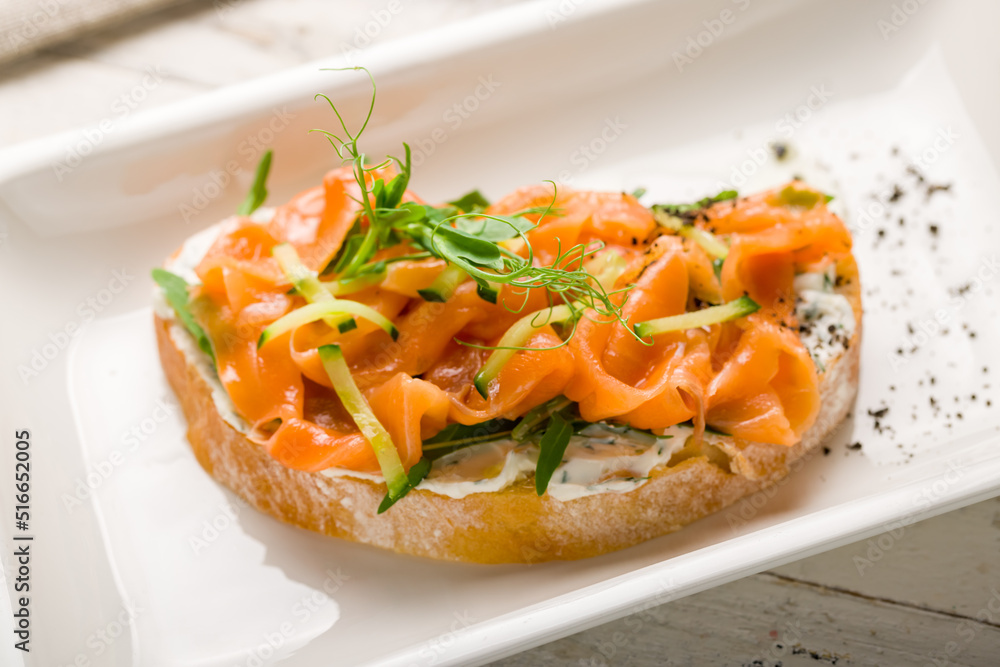 Bruschetta with salmon and cheese on white plate macro close up Bruschetta with salmon and cheese on white plate macro close up