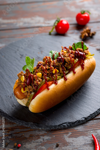 Fototapeta hot dog Mexican with jalapeno, corn and meat, chili con carne macro close up ver