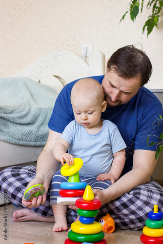 Father and baby boy building a pyramid toy.