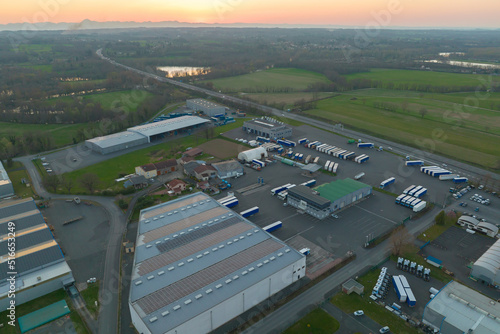 Aerial view of blue photovoltaic solar panels mounted on industrial building roof for producing green ecological electricity. Production of sustainable energy concept