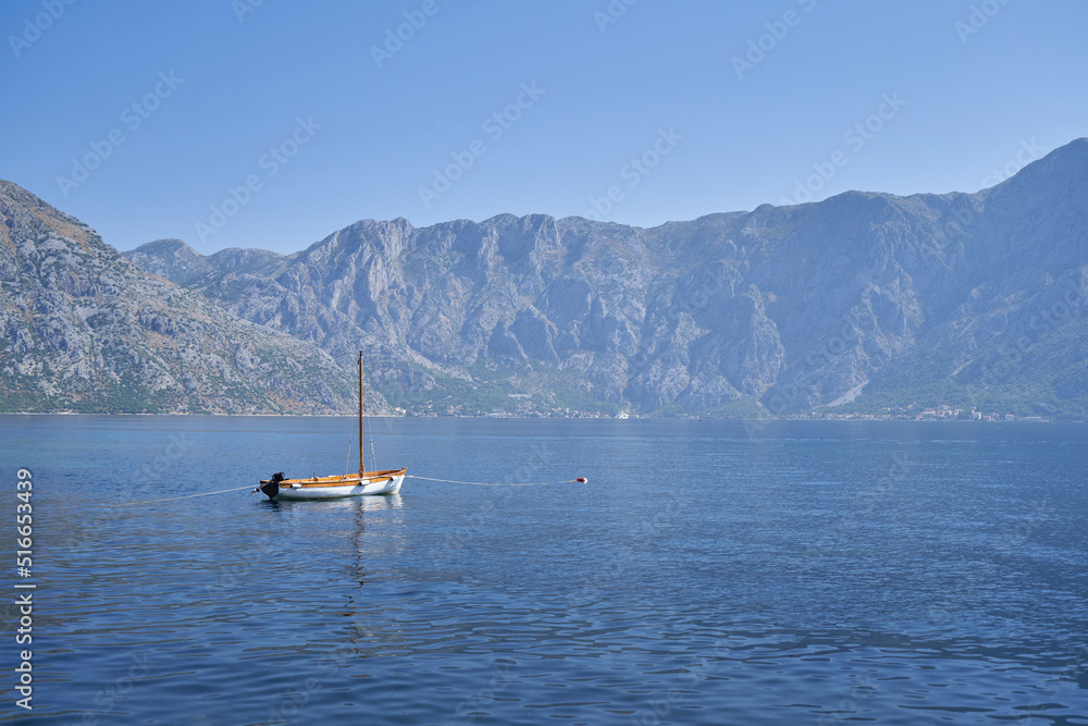 Small fishing boat in the sea against of mountains in Montenegro